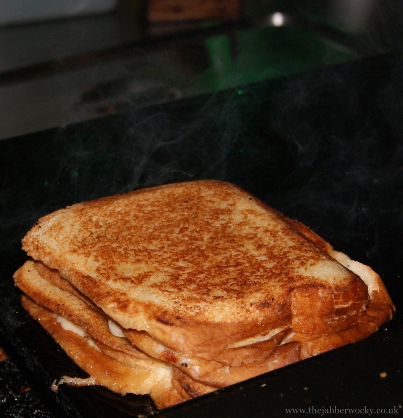 A 3 slice, three layer toastie sizzling on the sandwich presses