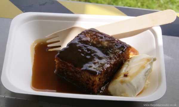 A generous chuck of warm sticky toffee pudding topped with toffee sauce and clotted cream
