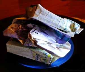 A burger or grilled cheese shape, made from two £5 notes and a £20. 
