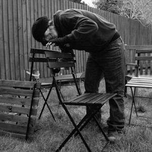 Black and white picture of Flic painting chairs